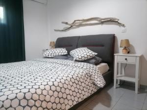 Schlafzimmer mit einem Bett mit grauem Kopfteil und Kissen in der Unterkunft On the beach in Koutsounári
