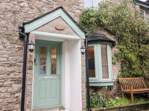 カーンフォースにあるEgremont Cottageの緑の扉とベンチのある家