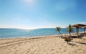 una spiaggia con sedie e ombrelloni e l'oceano di 1 Bedroom Awesome Apartment In St Cyprien a Saint-Cyprien-Plage