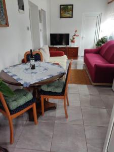 - un salon avec une table et un canapé dans l'établissement Apartman David-Dražice, à Dražice
