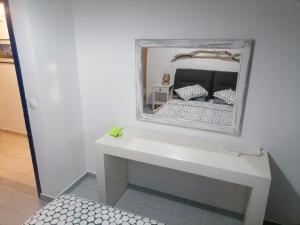 um espelho em cima de uma mesa branca com uma cama em On the beach em Koutsounári