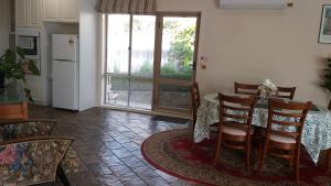 a dining room with a table and a kitchen at Sweet Holiday Home by the Golf Course in Canberra