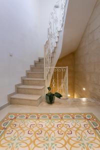 a staircase with a rug in a room with a stair case at Authentic Maltese 2-bedroom House with Terrace in Żejtun