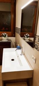 a bathroom with a white sink and a mirror at Le Altezze in Erice