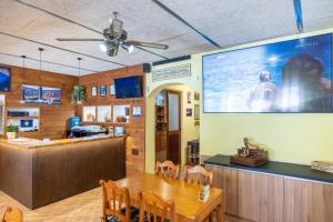 a dining room with a table and a large screen at Hostal Doris in Colonia Sant Jordi