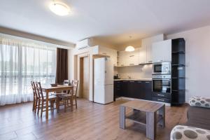 a kitchen and living room with a table and chairs at Balchik Sea View Apartments in Princess Residence in Balchik