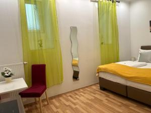 1 dormitorio con 1 cama, 1 silla y 1 ventana en Grand Central Station Apartments I contactless check-in, en Viena