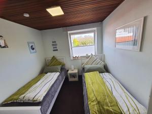 2 camas en una habitación pequeña con ventana en Villa Strandgut, en Wangerland