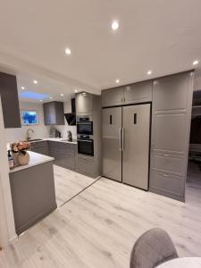a kitchen with stainless steel appliances and gray cabinets at Villa Astera in Västerås
