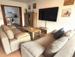 sala de estar con 2 sofás y TV de pantalla plana en Villa Strandgut, en Wangerland