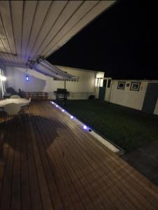 a deck at night with lights on the grass at Villa Astera in Västerås