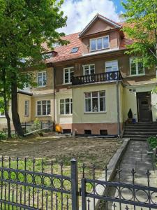 une maison avec une clôture devant elle dans l'établissement Najs Apartamenty z parkingiem, à Sopot