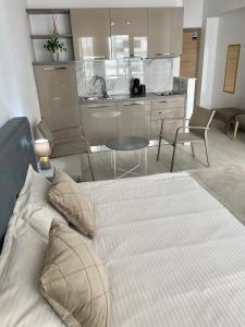 een slaapkamer met een groot bed en een keuken bij De Silva Studio Adia 4 in Mamaia