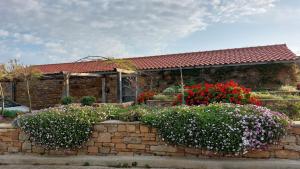 a brick house with flowers in front of it at ATARAXIA at Saravari Beach-Almond House in Áyios Aléxandros