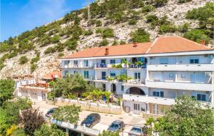 duży biały budynek z wzgórzem w tle w obiekcie Lovely Apartment In Stara Baska w mieście Stara Baška
