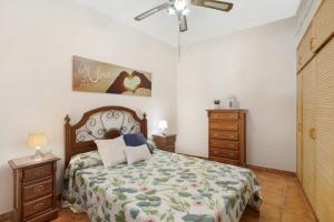 a bedroom with a bed and a ceiling fan at Las Arenas bajo in La Mareta