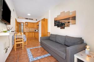 a living room with a couch and a kitchen at Las Arenas bajo in La Mareta