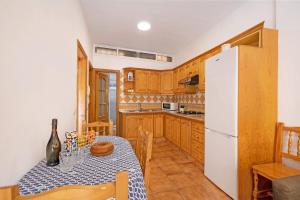 a kitchen with a table and a refrigerator at Las Arenas bajo in La Mareta