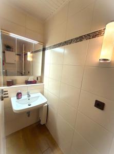 Baño blanco con lavabo y espejo en Villa Strandgut, en Wangerland