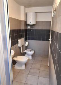 ein Badezimmer mit 2 WCs und einem Waschbecken in der Unterkunft Villa Antony piano terra in Granelli