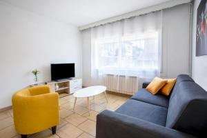 a living room with a blue couch and a yellow chair at Location La Londe in La Londe-les-Maures