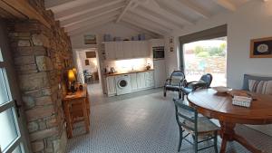 a kitchen and living room with a table and chairs at ATARAXIA at Saravari Beach-Almond House in Áyios Aléxandros