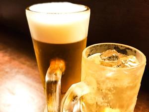 a mug of beer next to a glass of beer at HOTEL ZERO in Tatsuno