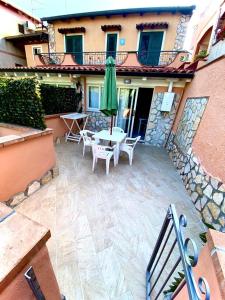 a patio with a table and a green umbrella at Case vacanze Azzurra in Marina di Camerota