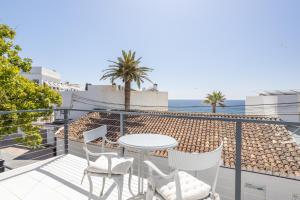a balcony with a table and chairs and the ocean at Sai Gayatri in Nerja