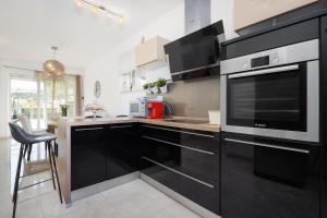 a kitchen with black cabinets and a microwave at Holiday Home Roko&Iva in Brodarica