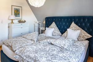a bed with a blue headboard and pillows at Ferienwohnung Trixi in Sexau