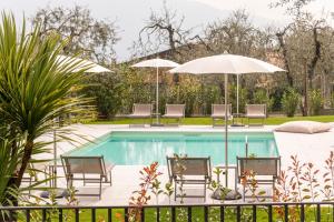 una piscina con mobili da giardino e ombrelloni di Evo Suites Apartments a Limone sul Garda