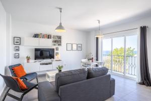 a living room with a couch and a tv at Relaxing Cozy Apartment in Nerja