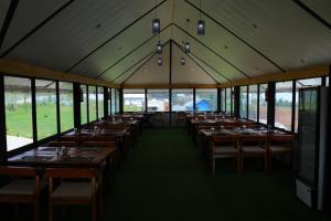 a large dining room with tables and windows at The Frame Resorts Ooty in Ooty