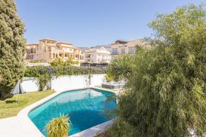a swimming pool in a yard with trees and houses at San Jose in Nerja +16 photos