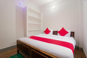 a bedroom with a large bed with red pillows at Super OYO New Suhani House in Rāmnagar