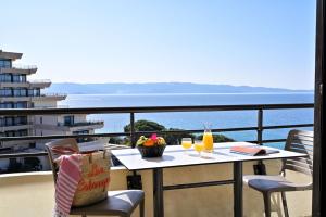 uma mesa com dois copos de sumo de laranja numa varanda em Résidence Les Calanques em Ajaccio