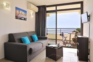 a living room with a couch and a balcony at Résidence Les Calanques in Ajaccio