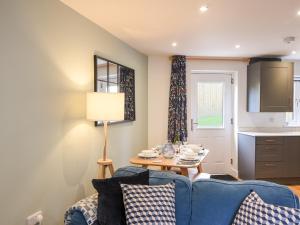a living room with a blue couch and a table at Conybeare Cottage in Lyme Regis