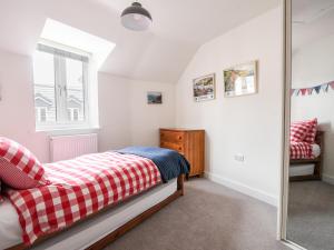 a bedroom with a bed and a mirror at Conybeare Cottage in Lyme Regis