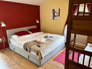 - une chambre avec un grand lit aux murs rouges dans l'établissement Gasthaus 3-Länderblick Mönichkirchen, à Mönichkirchen