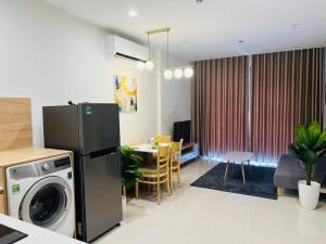 cocina y sala de estar con lavadora y secadora. en The Luxury Zen Origami Residence - Heart of Vinhomes Grand Park en Long Bình