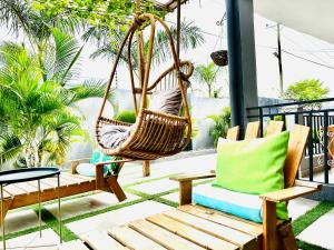 a porch with two chairs and a swing at Ultraluxurious HolidayVilla with an Infinity Pool in Apenkwa