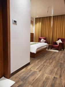 a hotel room with a bed and two chairs at Effotel by Sayaji Sarola in Bhor