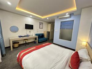 Habitación de hotel con cama grande y escritorio. en Capital O 1177 Saigon Sweet Hotel en Ho Chi Minh