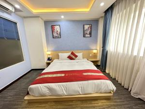 a bedroom with a large bed and a large window at Capital O 1177 Saigon Sweet Hotel in Ho Chi Minh City