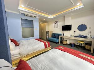 a hotel room with two beds and a flat screen tv at Capital O 1177 Saigon Sweet Hotel in Ho Chi Minh City