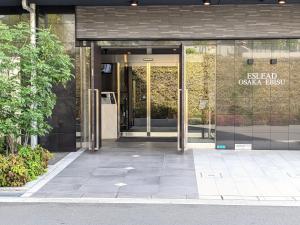 大阪的住宿－ESLEAD HOTEL Osaka Ebisu，带有玻璃门的办公大楼入口
