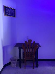 米瑞莎的住宿－purple villa，一间位于黑暗房间内的餐桌和椅子