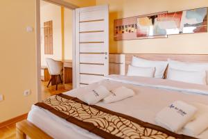 um quarto com uma cama grande e almofadas brancas em Hotel AirStar em Surčin
